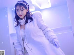 A woman in a white coat and gloves posing for a picture.
